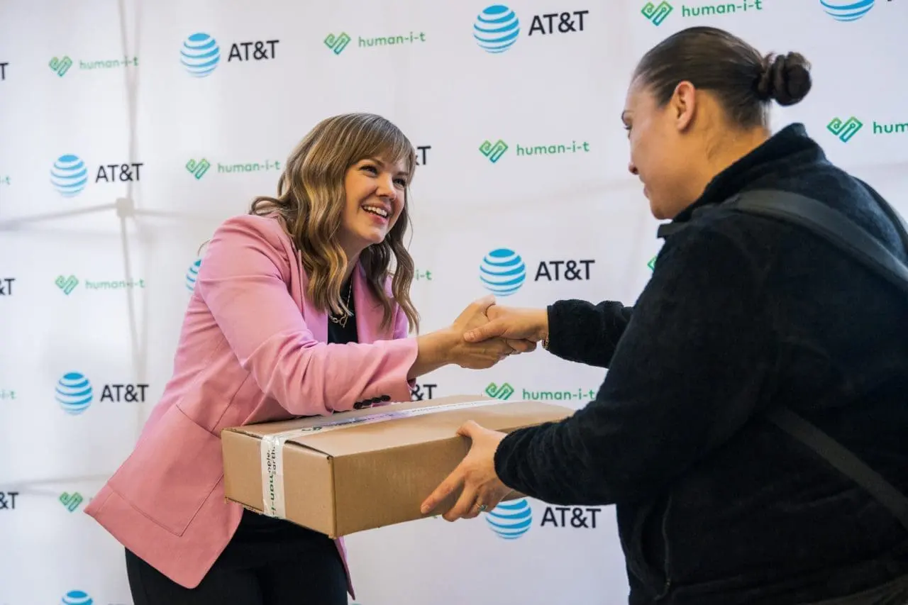 A woman receiving a box and giving a handshake