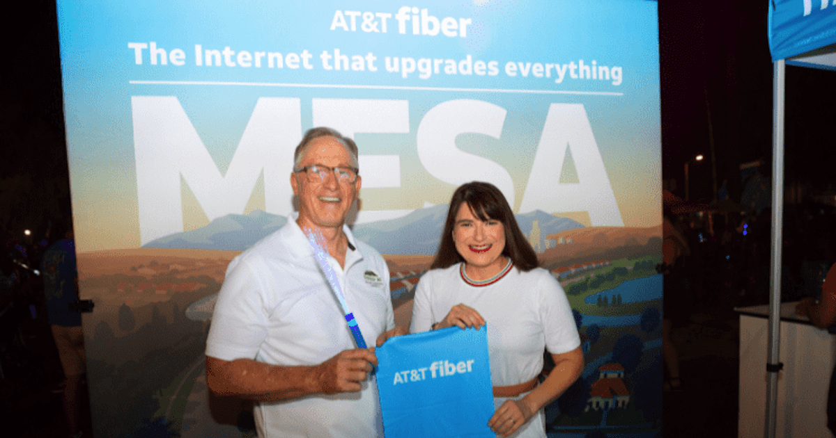 A man and a woman holding an AT&T fiber bag