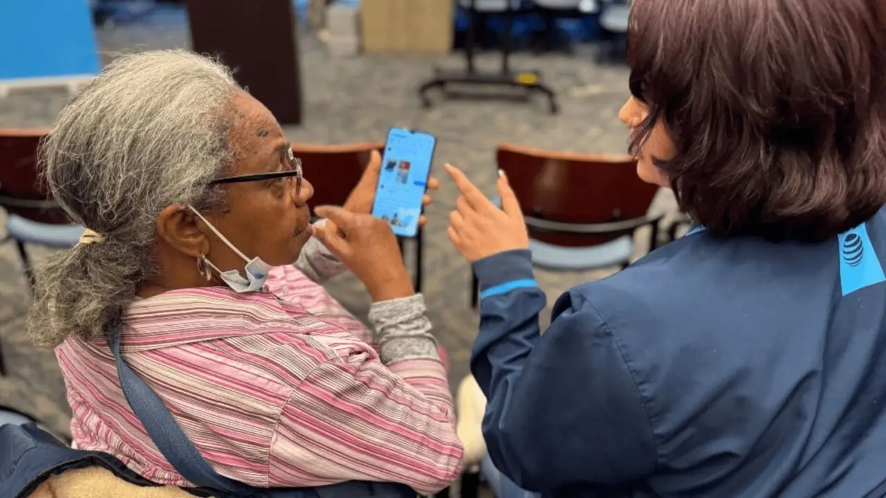 An ATT employee helping someone with their phone
