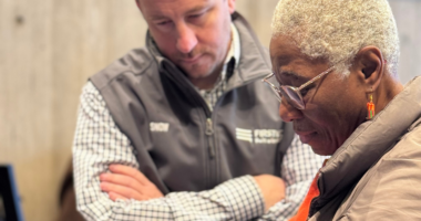 Man watching as woman uses cell phone