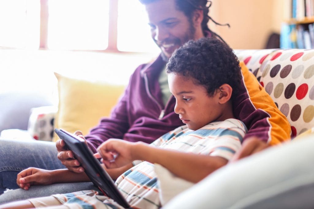 Father helping son with his homework on a tablet computer