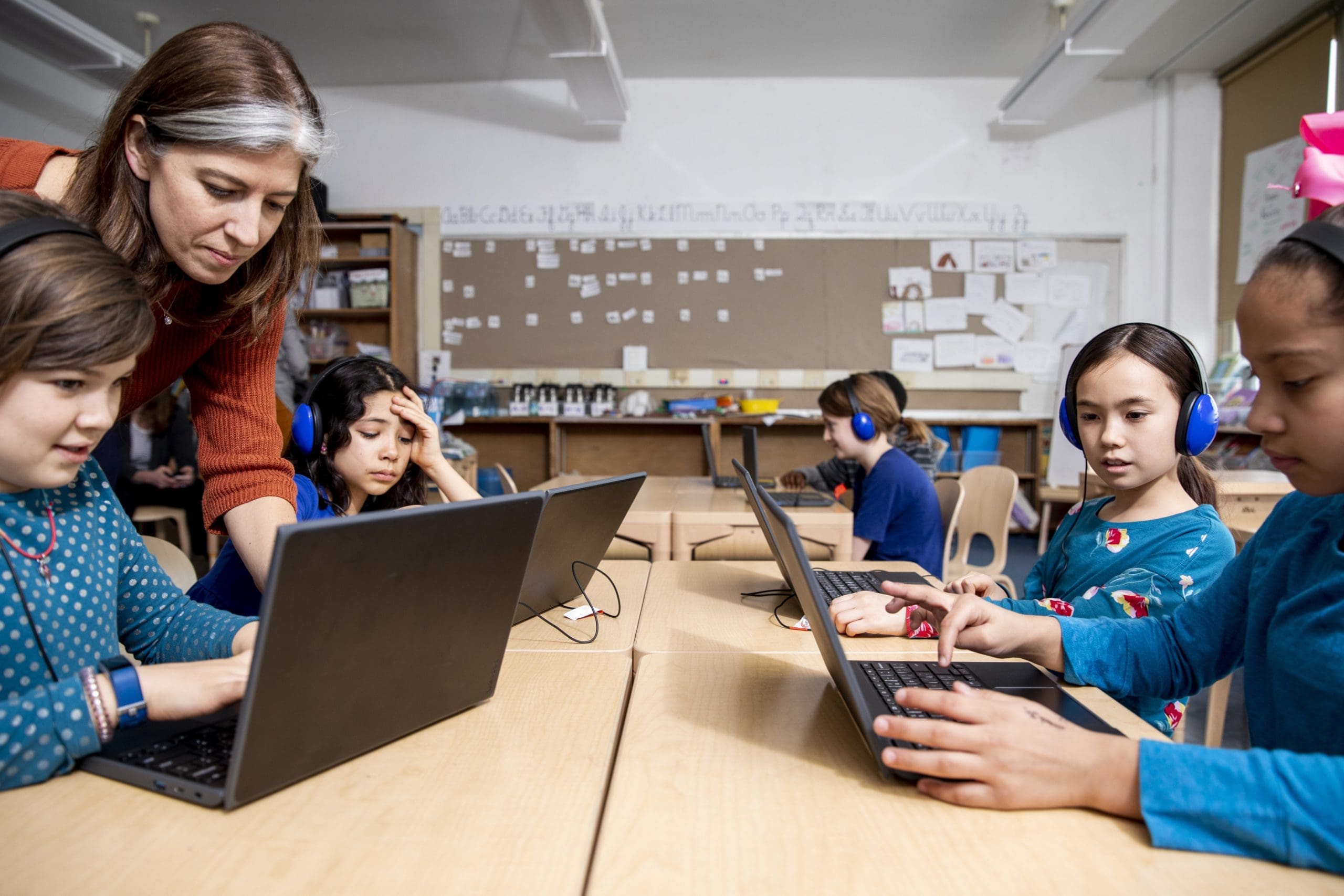 Teacher with children looking at laptop screen