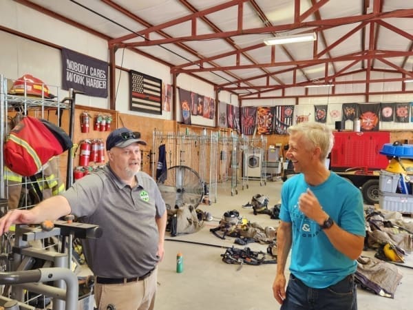 Two men talking and one giving a thumbs up