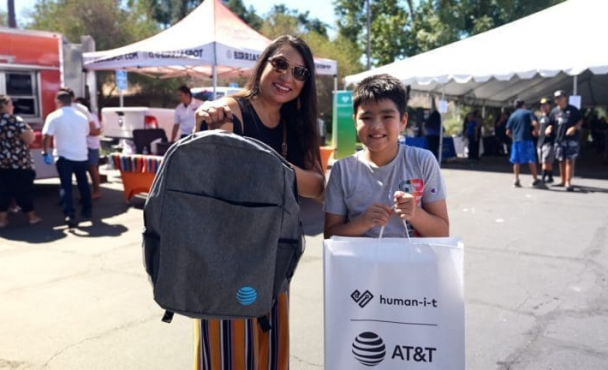 A woman with a backpack and a boy with a bag