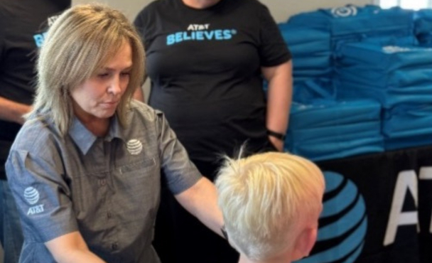 A woman in an AT&T shirt helping a child