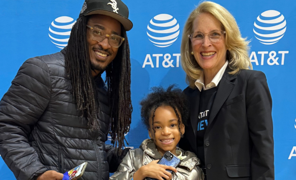 Three people smiling in front of an AT&T background