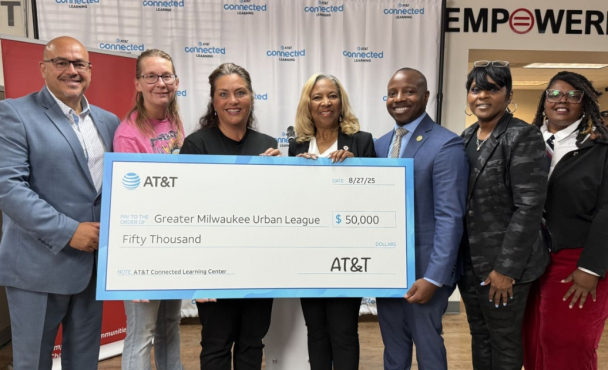 Seven people holding a novelty check