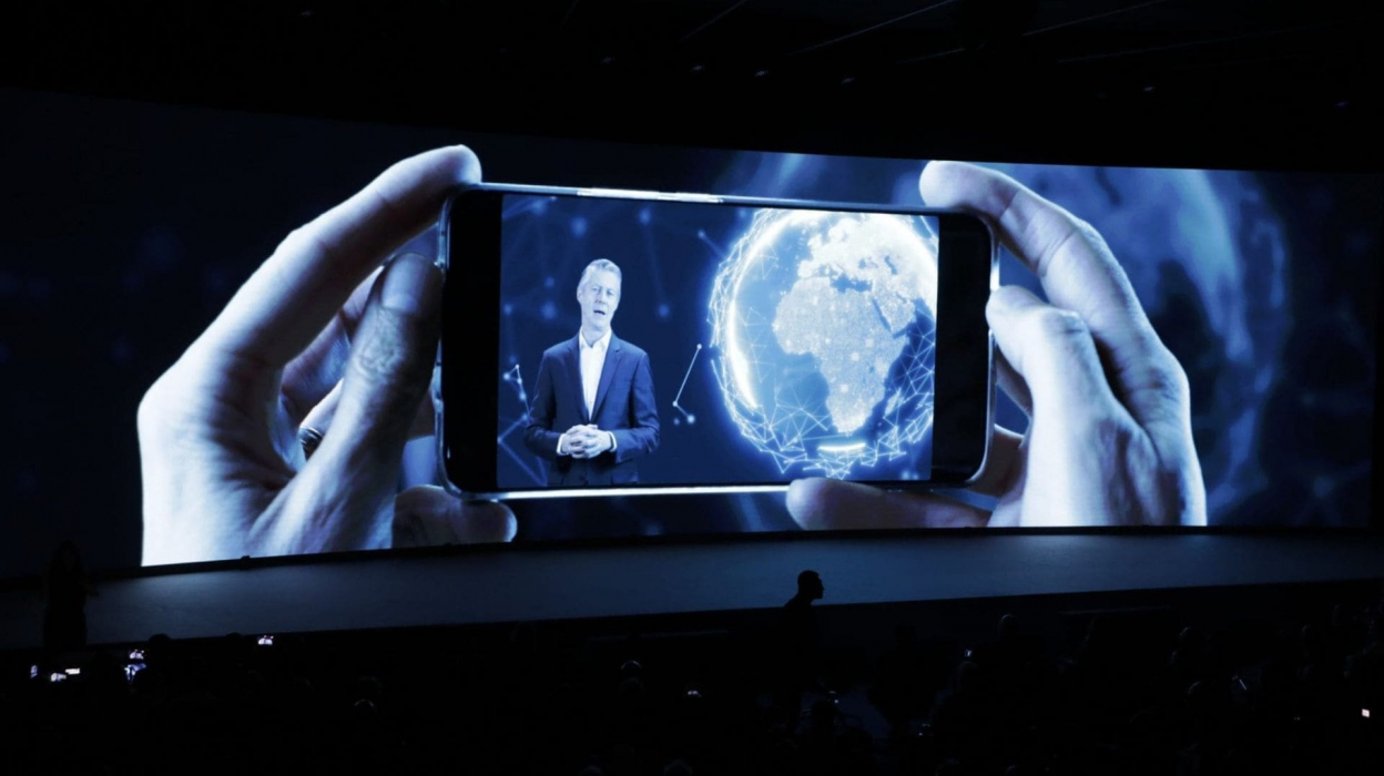 Holding up a phone on a screen with a person