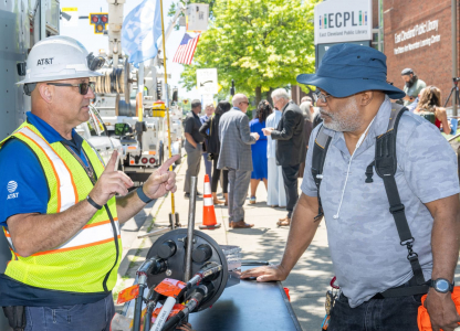 Man in PPE talking to man outside