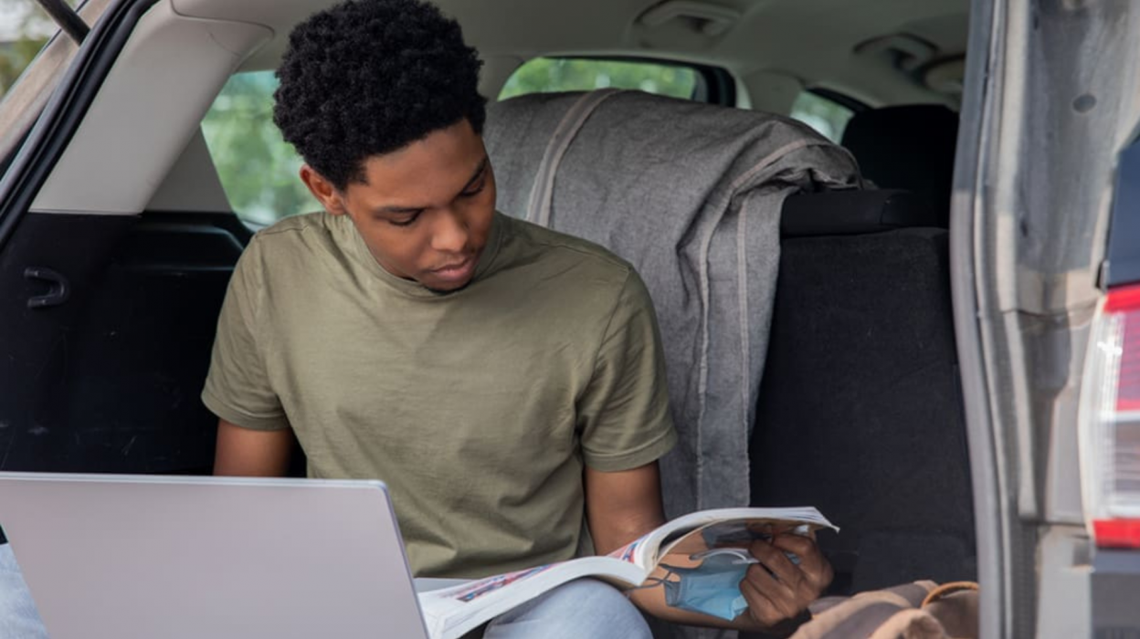 Student studying in the back of a car
