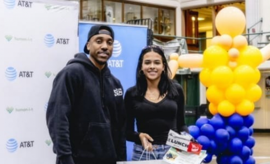 Two people holding items in front of an AT&T banner