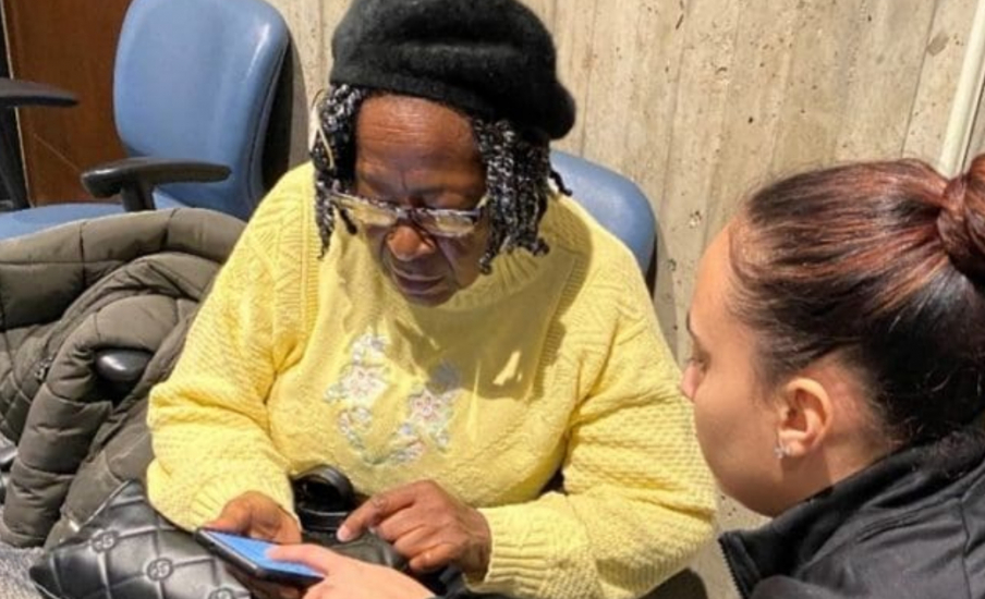A woman helping an older woman with her phone