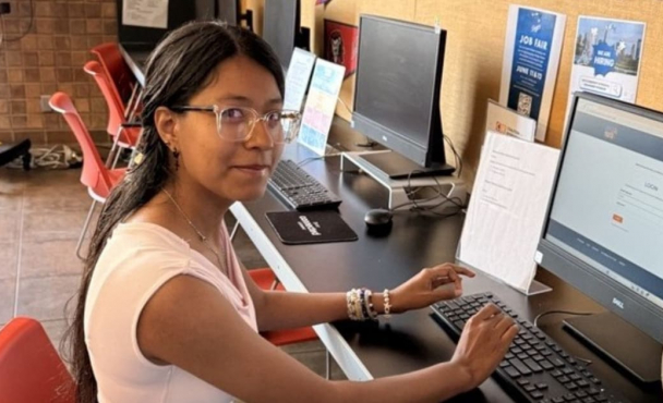 Young woman at computer looking at camera