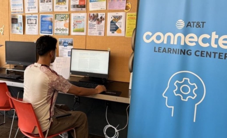 Person sitting at computer next to AT&T banner