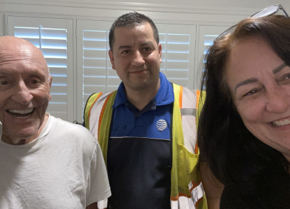 Two men, including one on a phone, and one woman taking a selfie