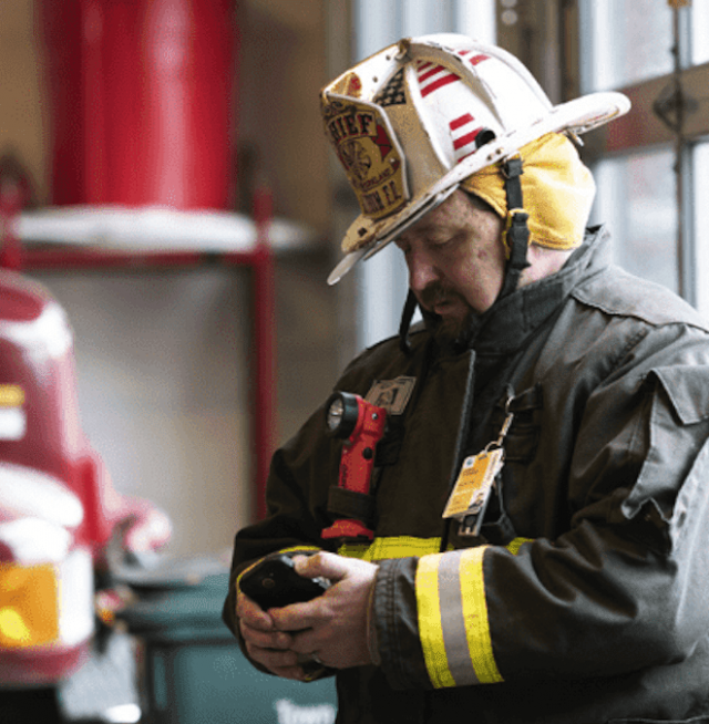 A firefighter looking at a device