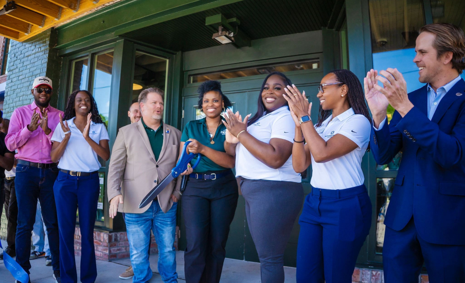 Ribbon cutting event in front of a green door