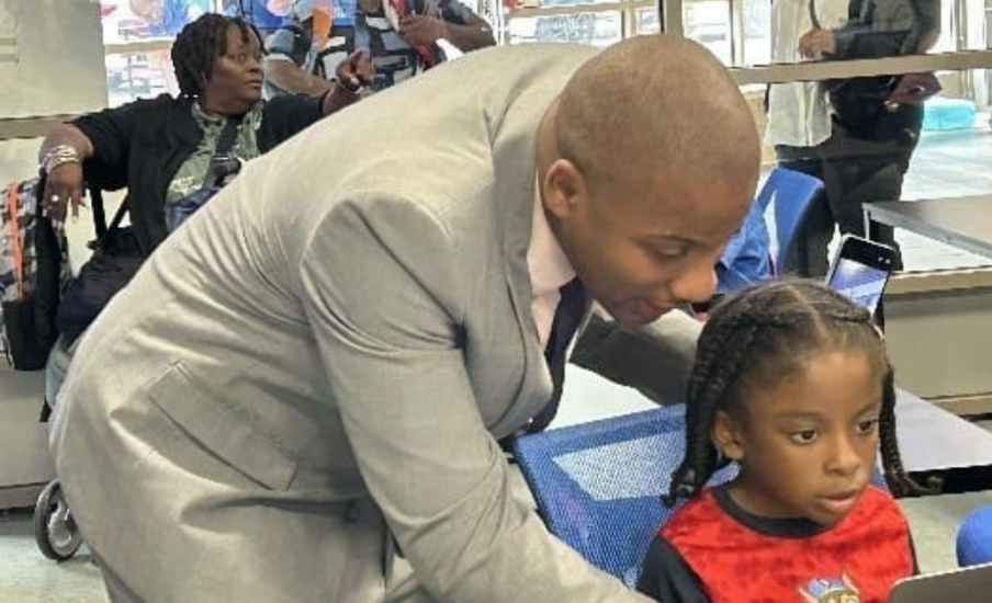 An adult talking to a student on a laptop