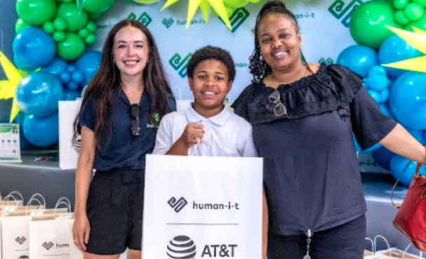 A group of people holding an AT&T bag, smiling.
