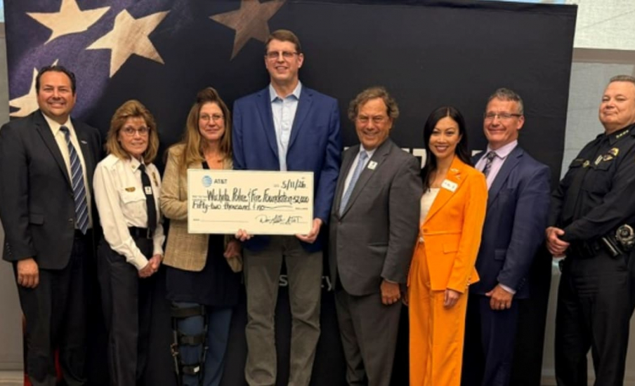 People smiling and holding a large check.