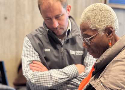 Man watching as woman uses cell phone