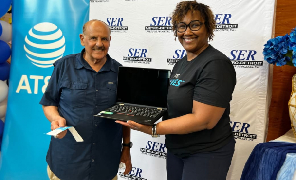 Two people smiling with laptop.