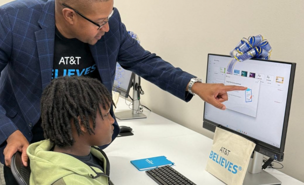 An adult helping a child on a desktop computer