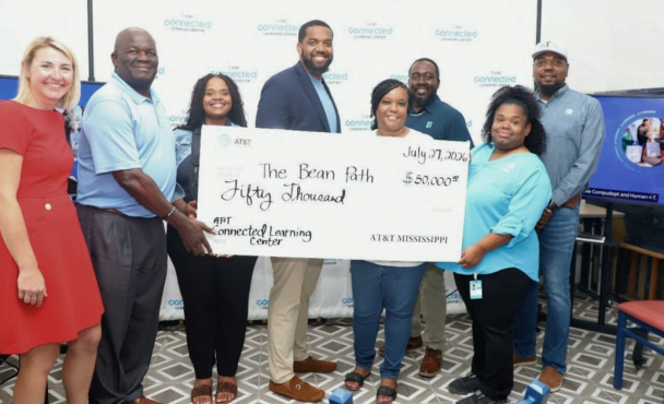 People smiling, holding large check