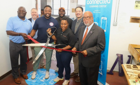 People smiling cutting ribbon at event