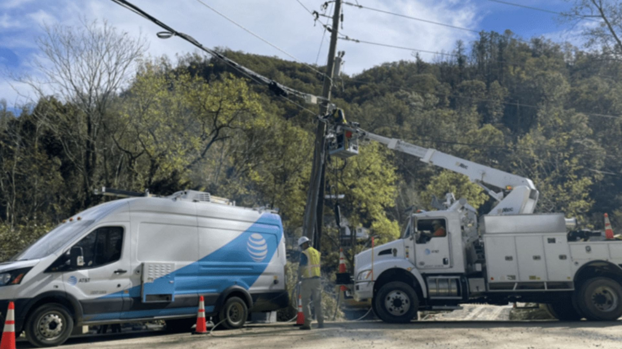 AT&T trucks working on a telephone pole.