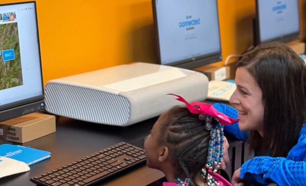 Woman helping child at computer