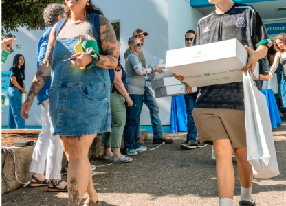 Children walking outside holding boxes and bags
