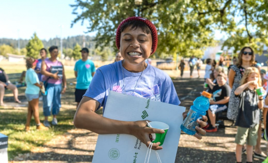 Child smiling at camera with box