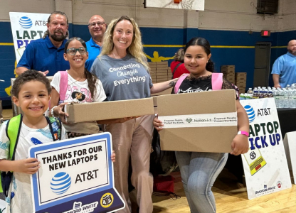 Adults and children smiling with laptops