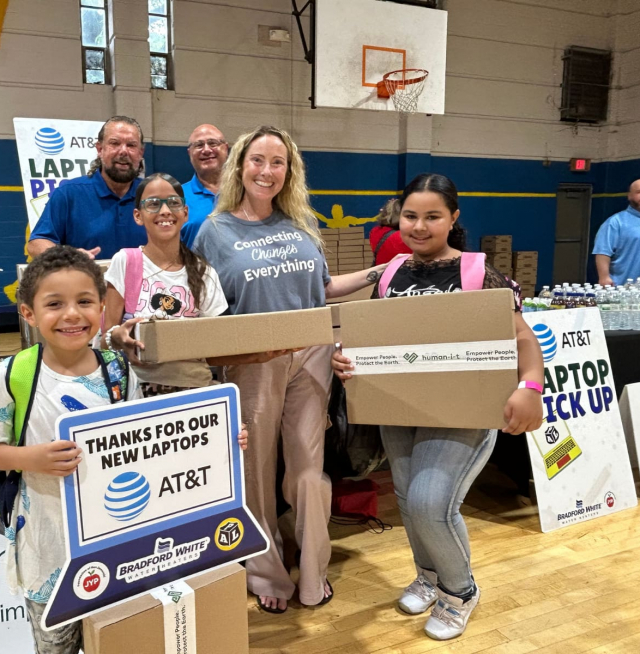 Adults and children smiling with laptops