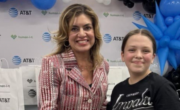 A woman handing a child a bag with the AT&T logo on it