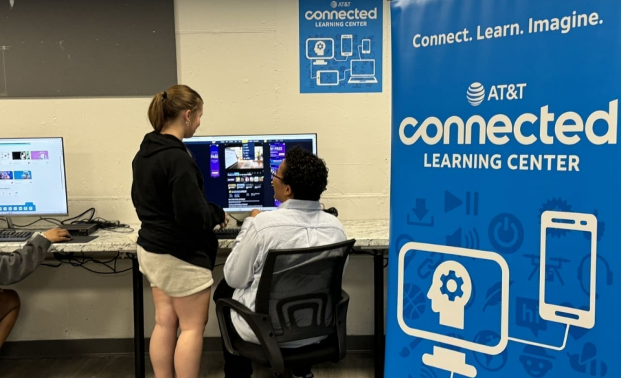 Two people standing in front of a computer