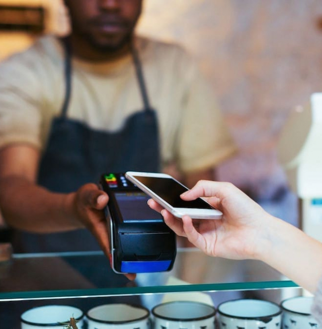 A person paying a cashier with their phone