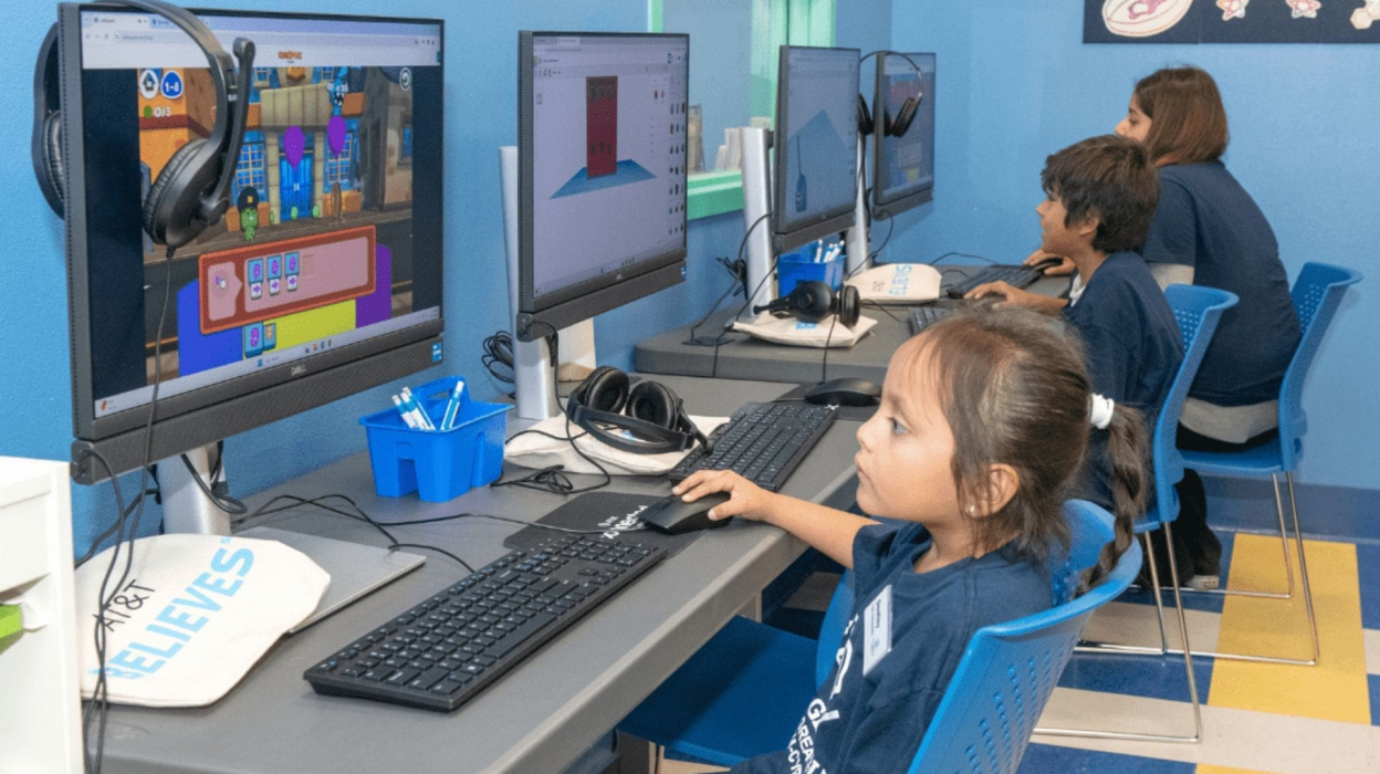Children sitting at a computer in a computer lab