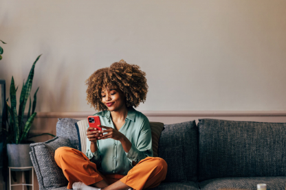woman-smiles-while-looking-at-phone